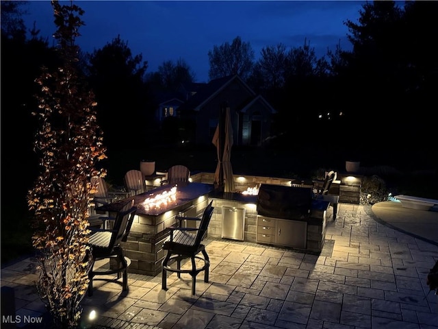 7966 Meadowbrooke Trl, Poland, OH 44514 - patio at twilight featuring an outdoor fire pit and exterior kitchen
