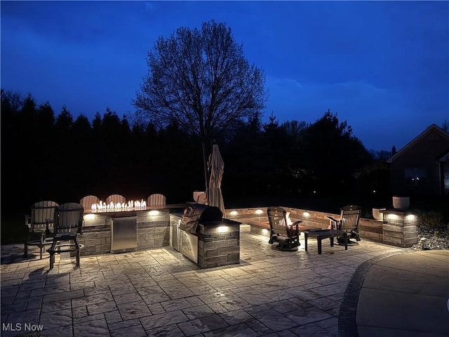 7966 Meadowbrooke Trl, Poland, OH 44514 - patio at twilight with a fire pit and an outdoor kitchen