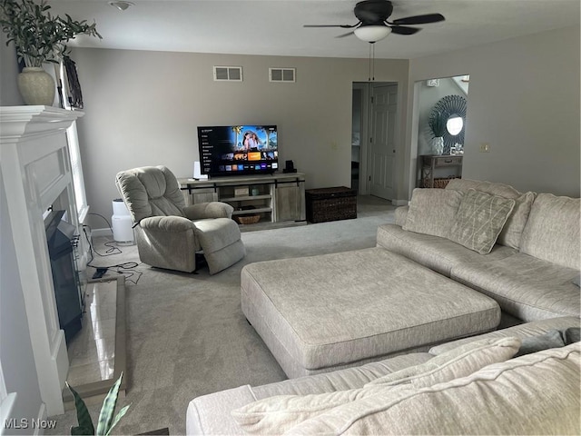 7966 Meadowbrooke Trl, Poland, OH 44514 - living area with light carpet, a glass covered fireplace, a ceiling fan, and visible vents