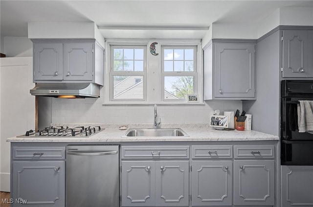 kitchen featuring under cabinet range hood, stainless steel appliances, gray cabinets, and a sink