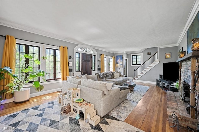 living room with stairs, wood-type flooring, and baseboards