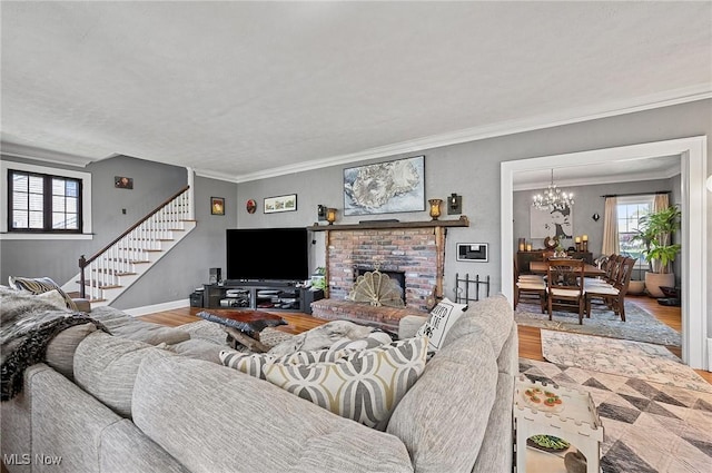 living room featuring crown molding, a wealth of natural light, wood finished floors, and stairs