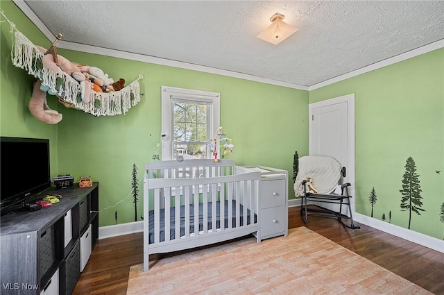 bedroom featuring ornamental molding, a textured ceiling, and wood finished floors