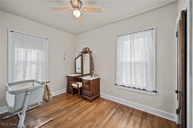 miscellaneous room with plenty of natural light, baseboards, a ceiling fan, and wood finished floors