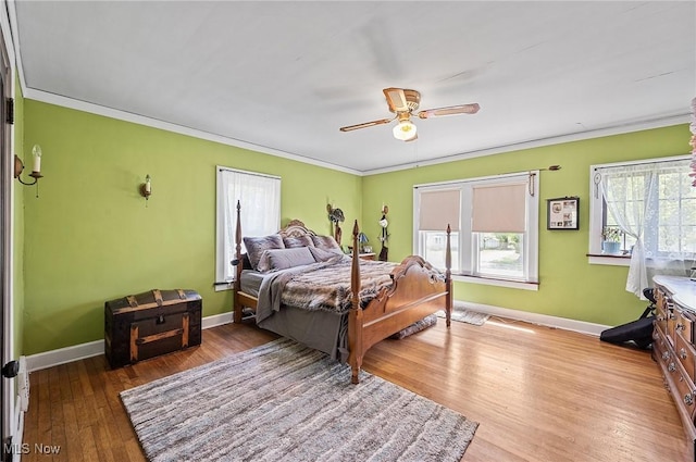 bedroom featuring ceiling fan, ornamental molding, baseboards, and wood finished floors