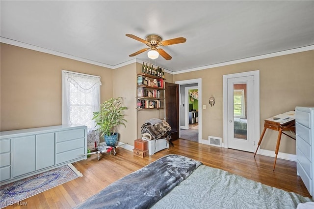 sitting room featuring wood finished floors, a ceiling fan, crown molding, visible vents, and baseboards