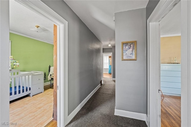 hallway with baseboards and wood finished floors