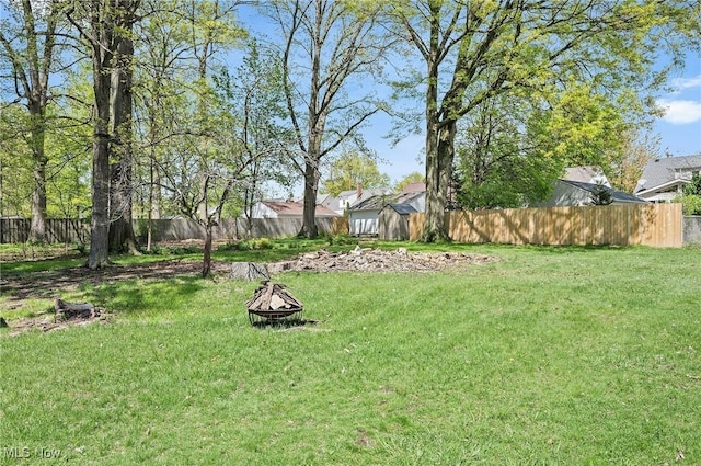 view of yard with a fire pit and fence