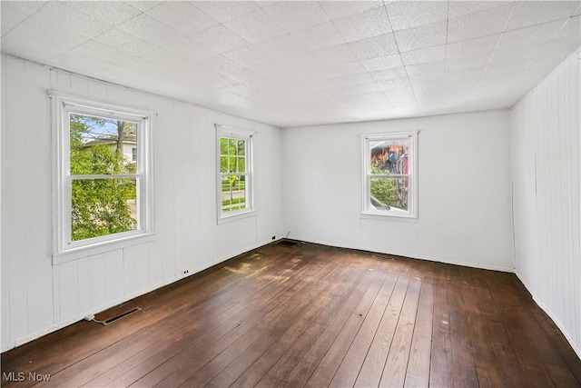 empty room featuring hardwood / wood-style floors and visible vents