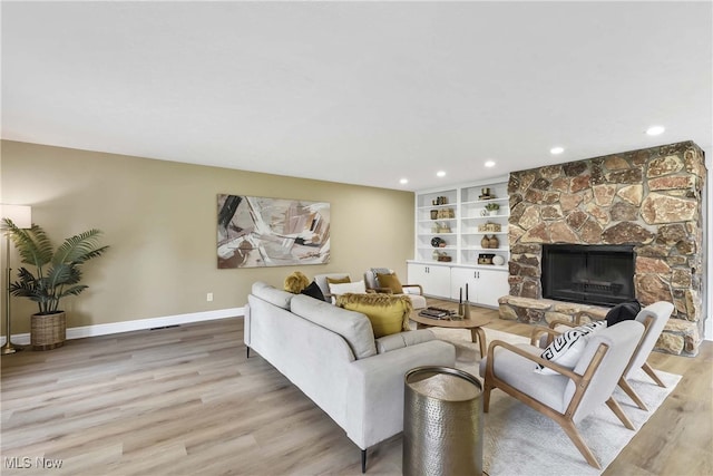 10836 Watercress Rd, Strongsville, OH 44149 - living room with recessed lighting, baseboards, a stone fireplace, and light wood-style floors