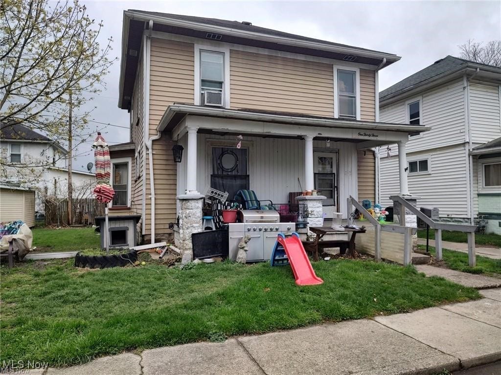view of front of house featuring covered porch and a front yard