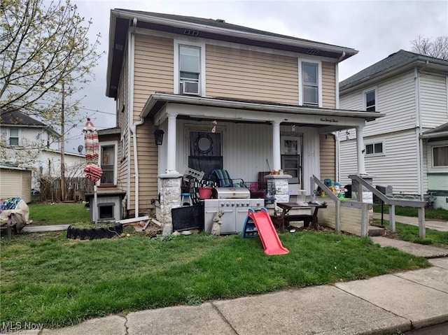 view of front of house featuring covered porch and a front yard