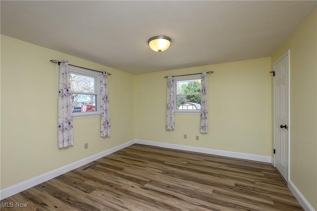 1181 S Broadway, New Philadelphia, OH 44663 - empty room featuring plenty of natural light, visible vents, wood finished floors, and baseboards