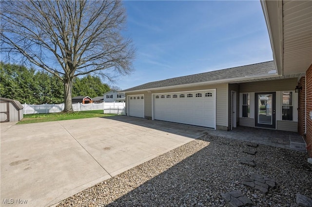 1181 S Broadway, New Philadelphia, OH 44663 - view of side of property with driveway, fence, a shed, an outdoor structure, and an attached garage