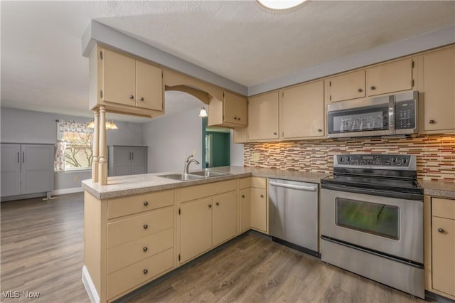 1181 S Broadway, New Philadelphia, OH 44663 - kitchen with cream cabinets, backsplash, a sink, and appliances with stainless steel finishes