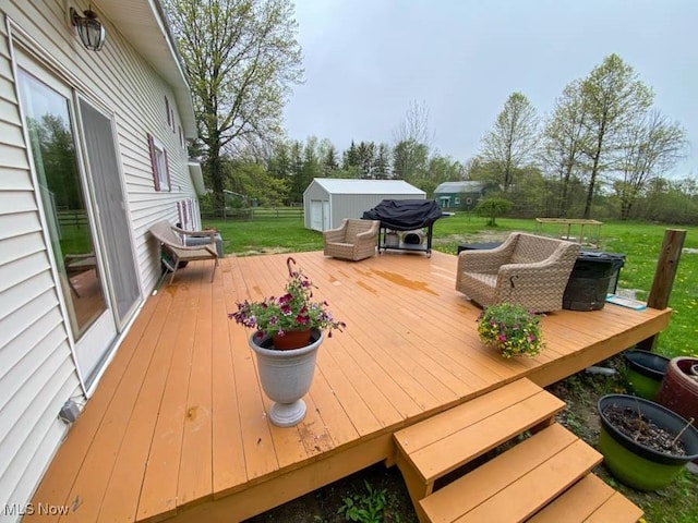 wooden deck with a lawn and an outdoor structure