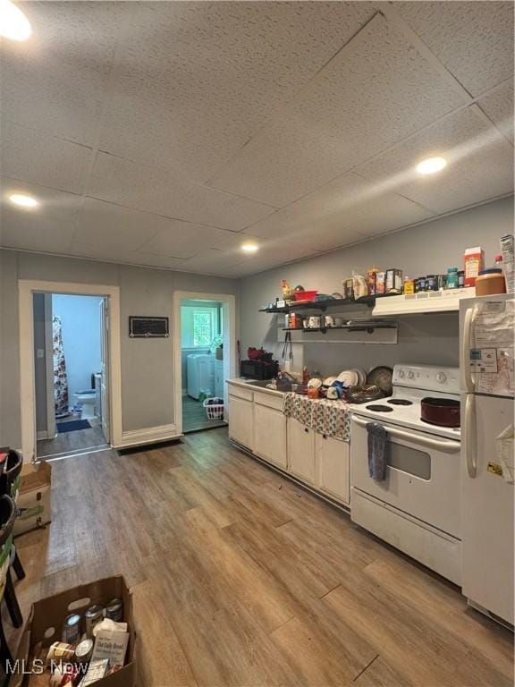 722 John St, Coshocton, OH 43812 - kitchen featuring white appliances, light wood-style floors, a paneled ceiling, and open shelves
