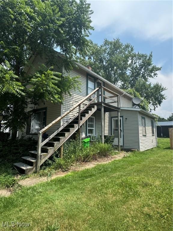 722 John St, Coshocton, OH 43812 - rear view of property featuring stairs, a yard, and a chimney