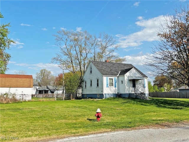 bungalow-style home with roof with shingles, fence, a front lawn, and a chimney