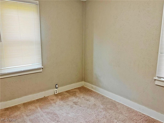 unfurnished room with baseboards and carpet flooring
