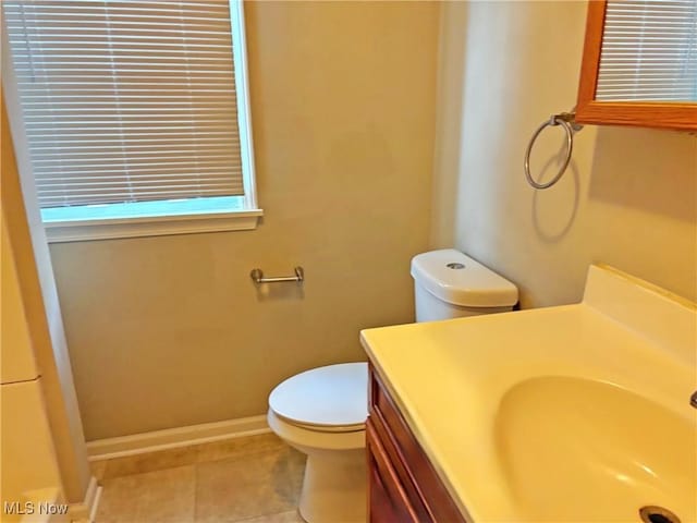 bathroom with vanity, toilet, baseboards, and tile patterned flooring