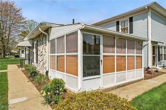 view of property exterior with a sunroom
