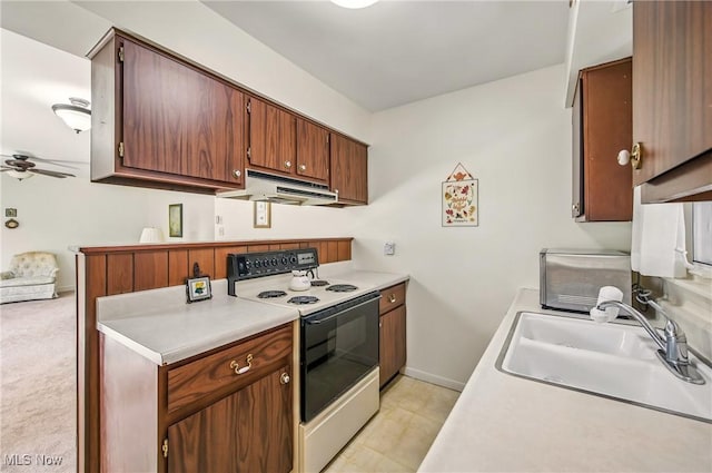 kitchen featuring a sink, under cabinet range hood, light countertops, a ceiling fan, and electric range