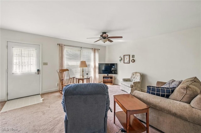 living room featuring light colored carpet, baseboards, and ceiling fan