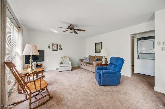 living room featuring a ceiling fan, stacked washing maching and dryer, and carpet floors