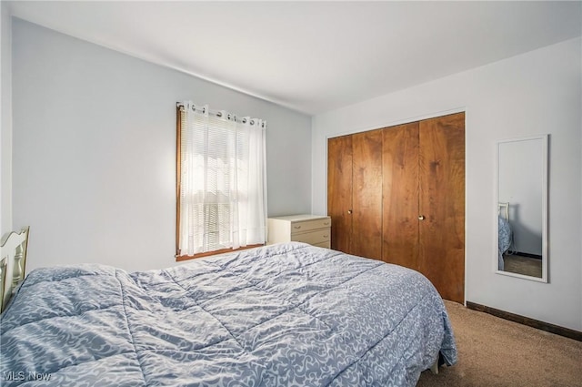 carpeted bedroom featuring a closet and baseboards