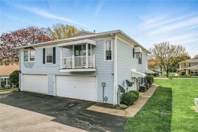 view of home's exterior with a yard, aphalt driveway, and a garage