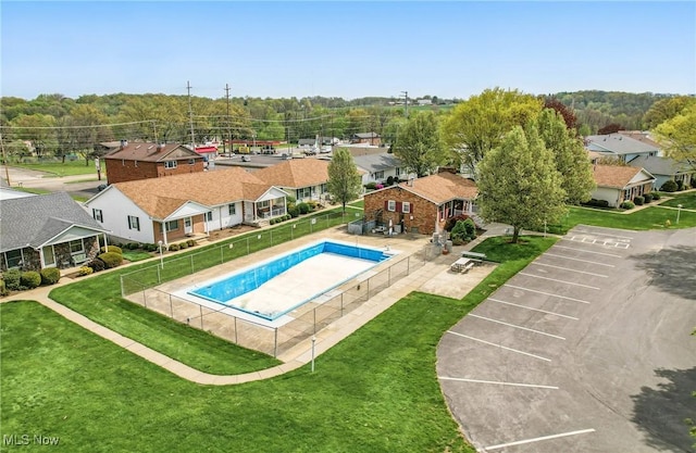pool featuring a yard, a residential view, and fence