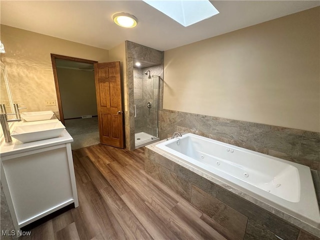 5869 Amy Boyle Rd NE, Brookfield, OH 44403 - full bathroom featuring double vanity, a jetted tub, wood finished floors, a skylight, and a shower stall