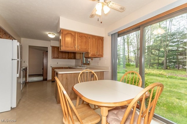 9122 Katherine Ct, Mentor, OH 44060 - kitchen with brown cabinets, a ceiling fan, freestanding refrigerator, light floors, and light countertops