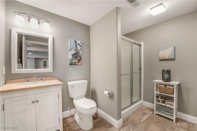 bathroom featuring a shower stall, visible vents, and wood finished floors