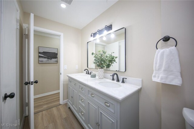 6544 Nancy Dr, North Olmsted, OH 44070 - bathroom with double vanity, wood finished floors, baseboards, and a sink