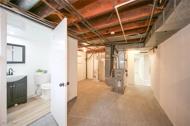 6544 Nancy Dr, North Olmsted, OH 44070 - unfinished basement featuring a sink, gas water heater, heating unit, and concrete block wall