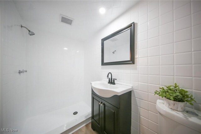 6544 Nancy Dr, North Olmsted, OH 44070 - bathroom featuring toilet, a stall shower, tile walls, visible vents, and vanity