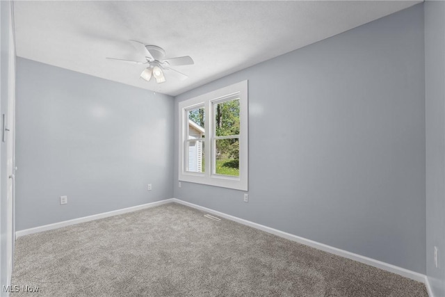 spare room featuring a ceiling fan, baseboards, visible vents, and carpet floors