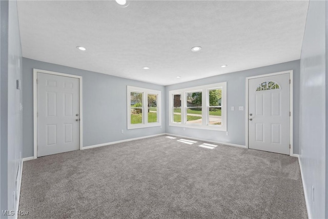 unfurnished living room with carpet, baseboards, and recessed lighting