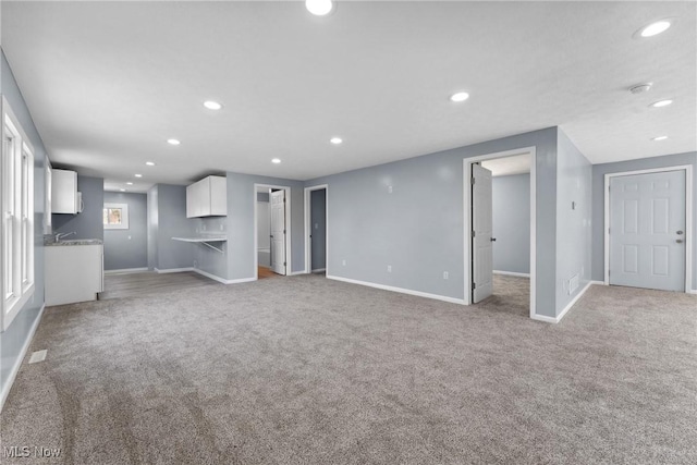 unfurnished living room with light carpet and recessed lighting