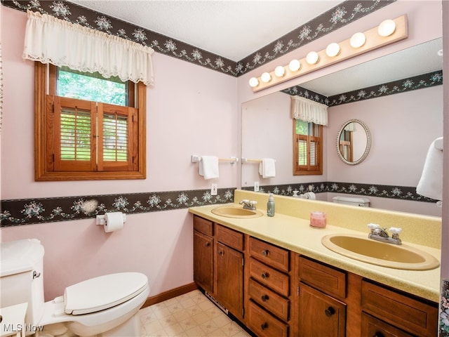 bathroom featuring tile patterned floors, toilet, and a sink