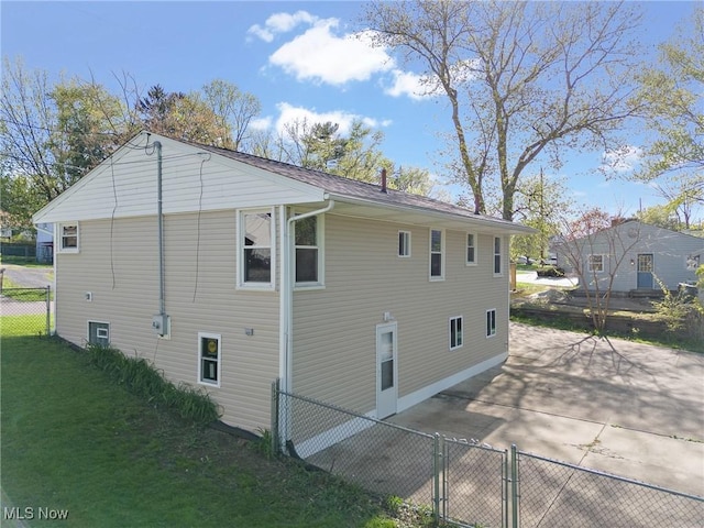 view of side of property featuring a yard, fence, and a patio