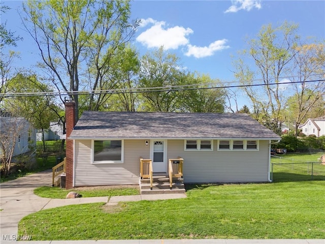 ranch-style home with a chimney, a front lawn, and fence