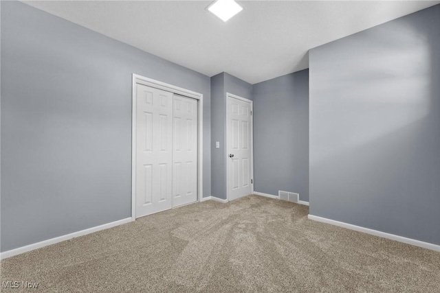 unfurnished bedroom with a closet, visible vents, baseboards, and carpet floors