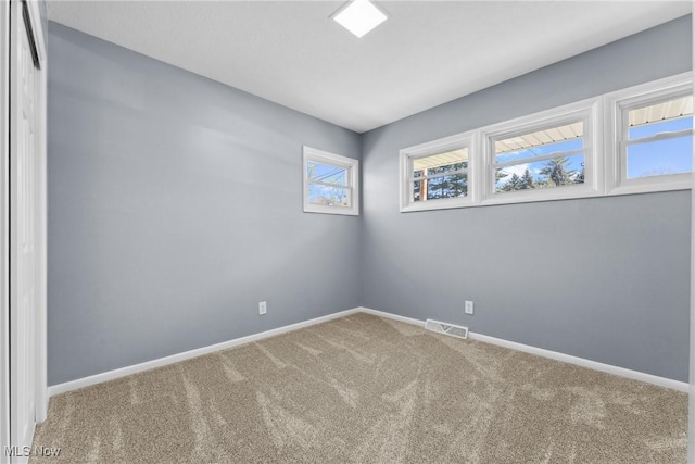 carpeted empty room with baseboards and visible vents