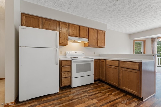 kitchen with a peninsula, white appliances, brown cabinets, under cabinet range hood, and dark wood-style floors