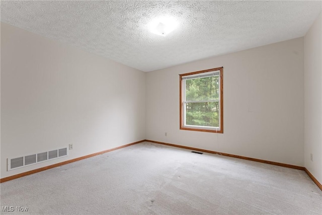 empty room with baseboards, visible vents, and carpet