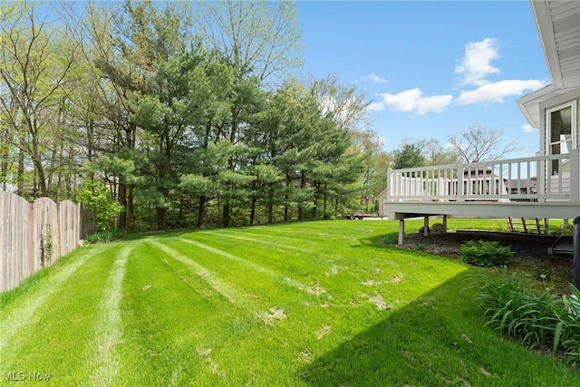 view of yard featuring fence and a deck