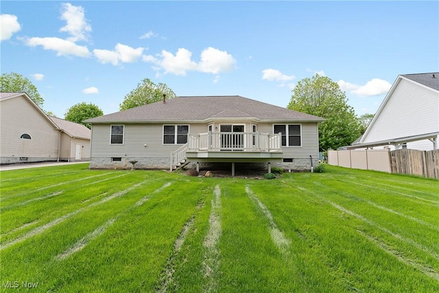 back of house featuring a lawn, crawl space, fence, and a wooden deck